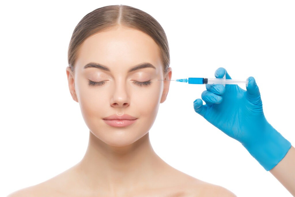 Young attractive woman pictured with eyes closed during botox injection.