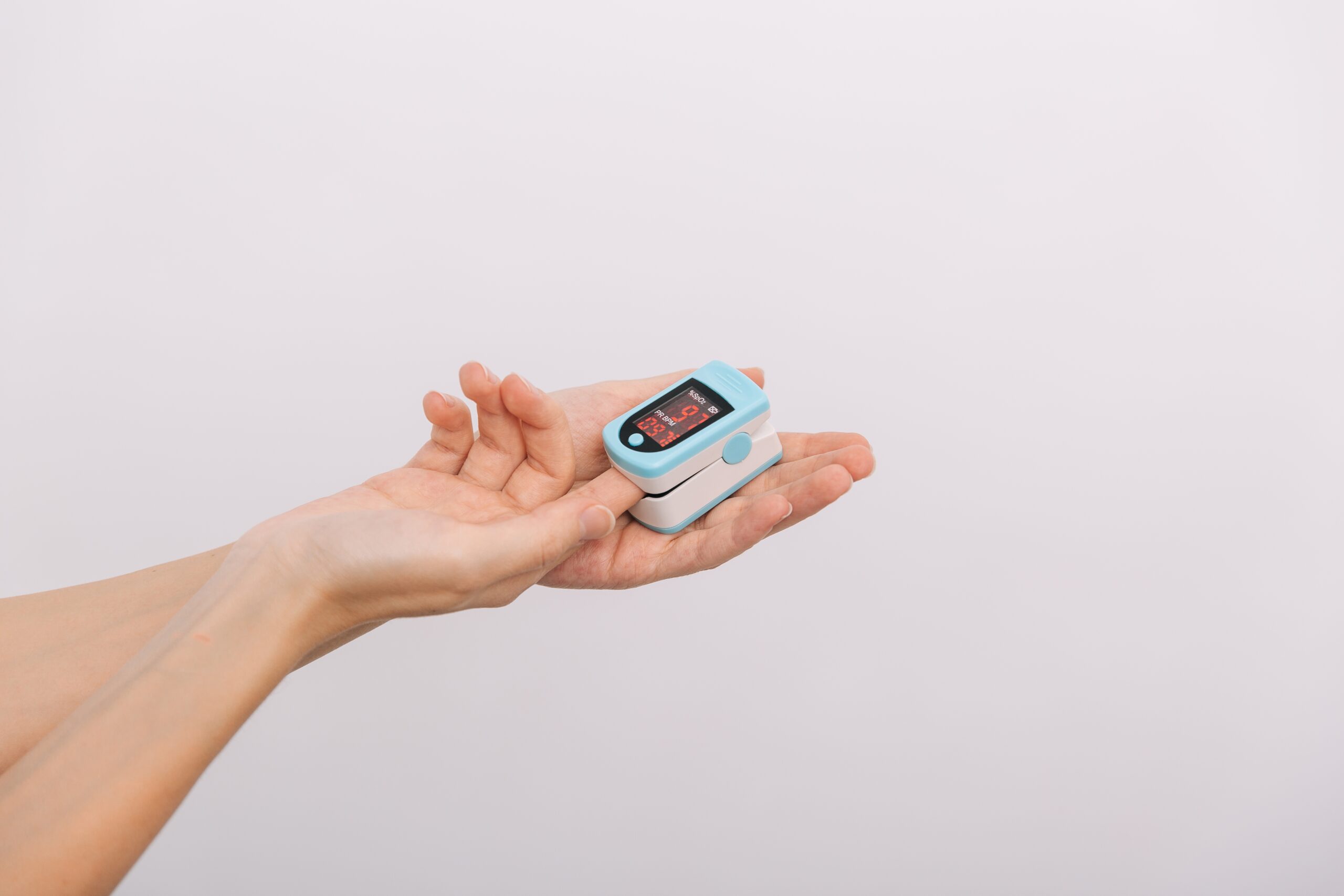 Pulse Oximeter With Hand Of Doctor Isolated On White.