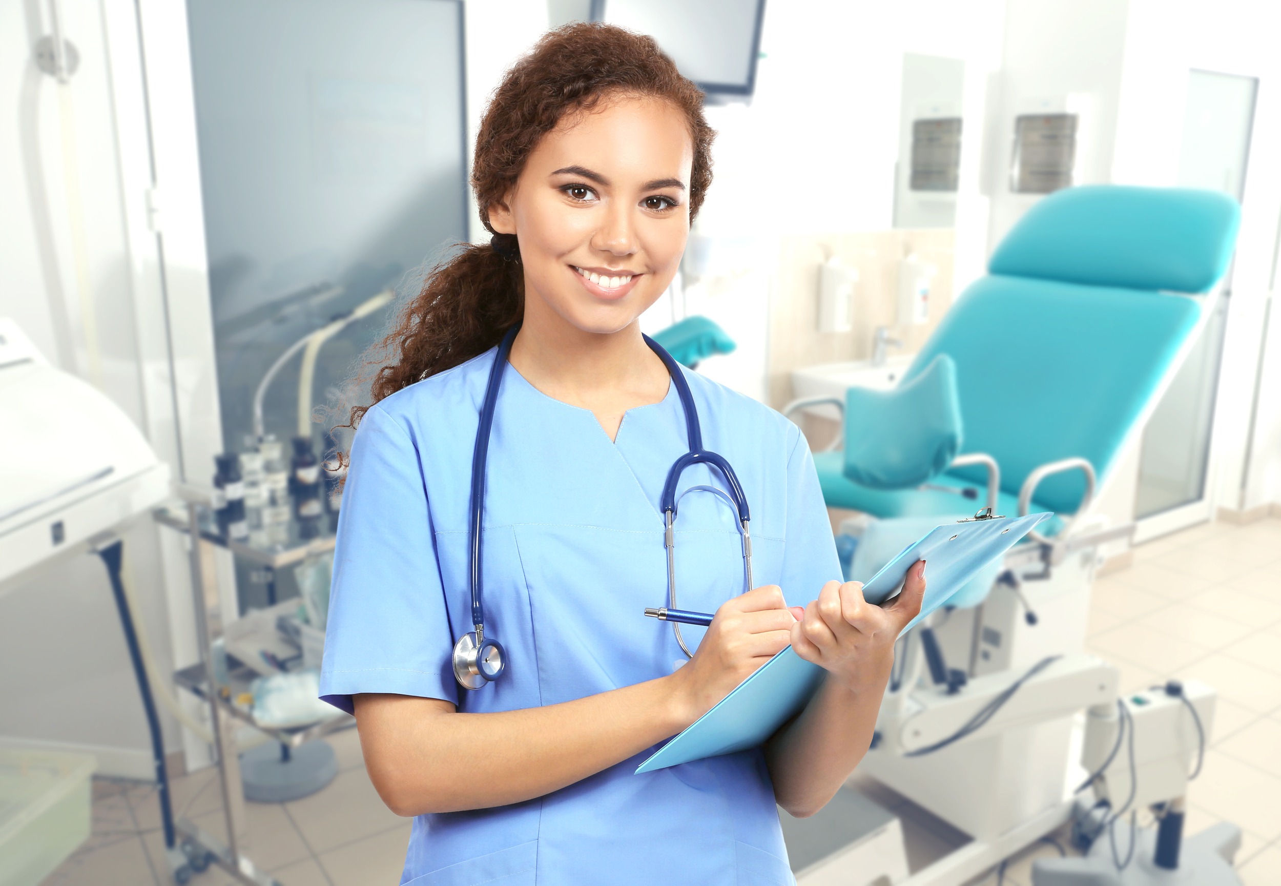 Professional female doctor with clipboard on blurred consulting room background. Gynecology concept.
